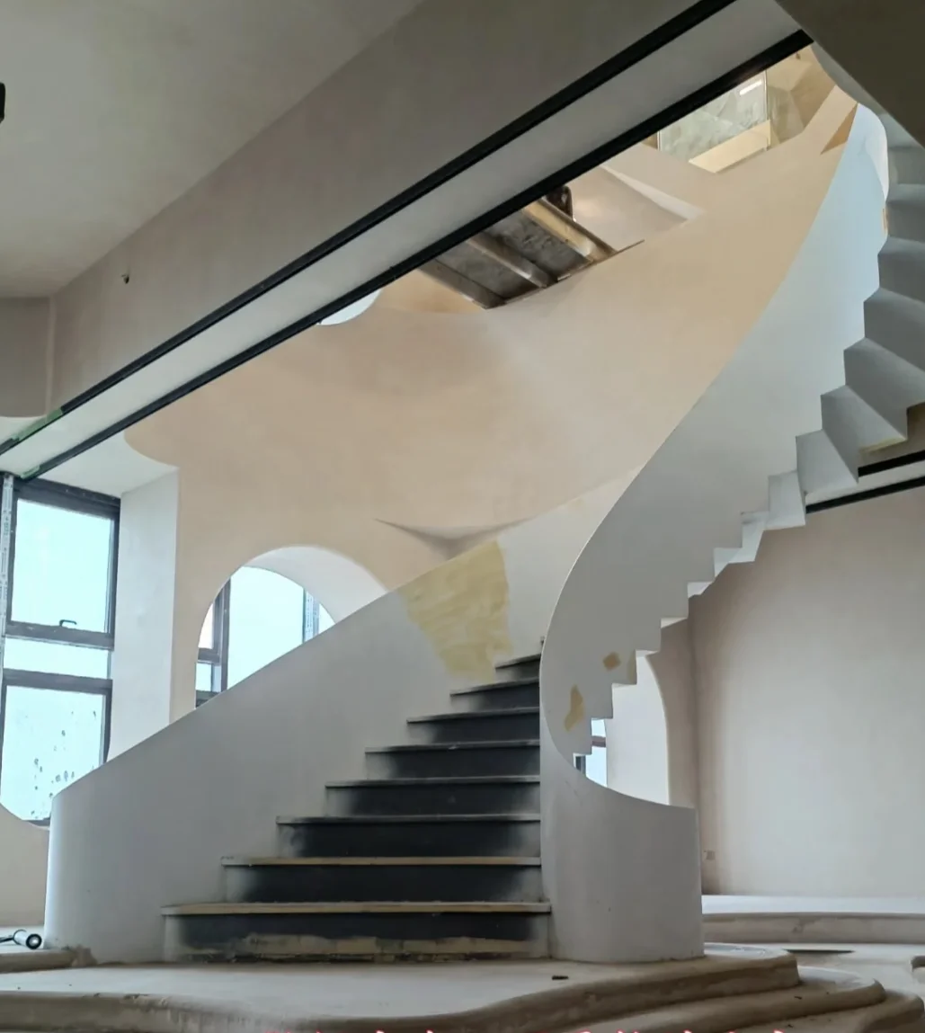Curved staircase construction and surface finishing during on-site installation