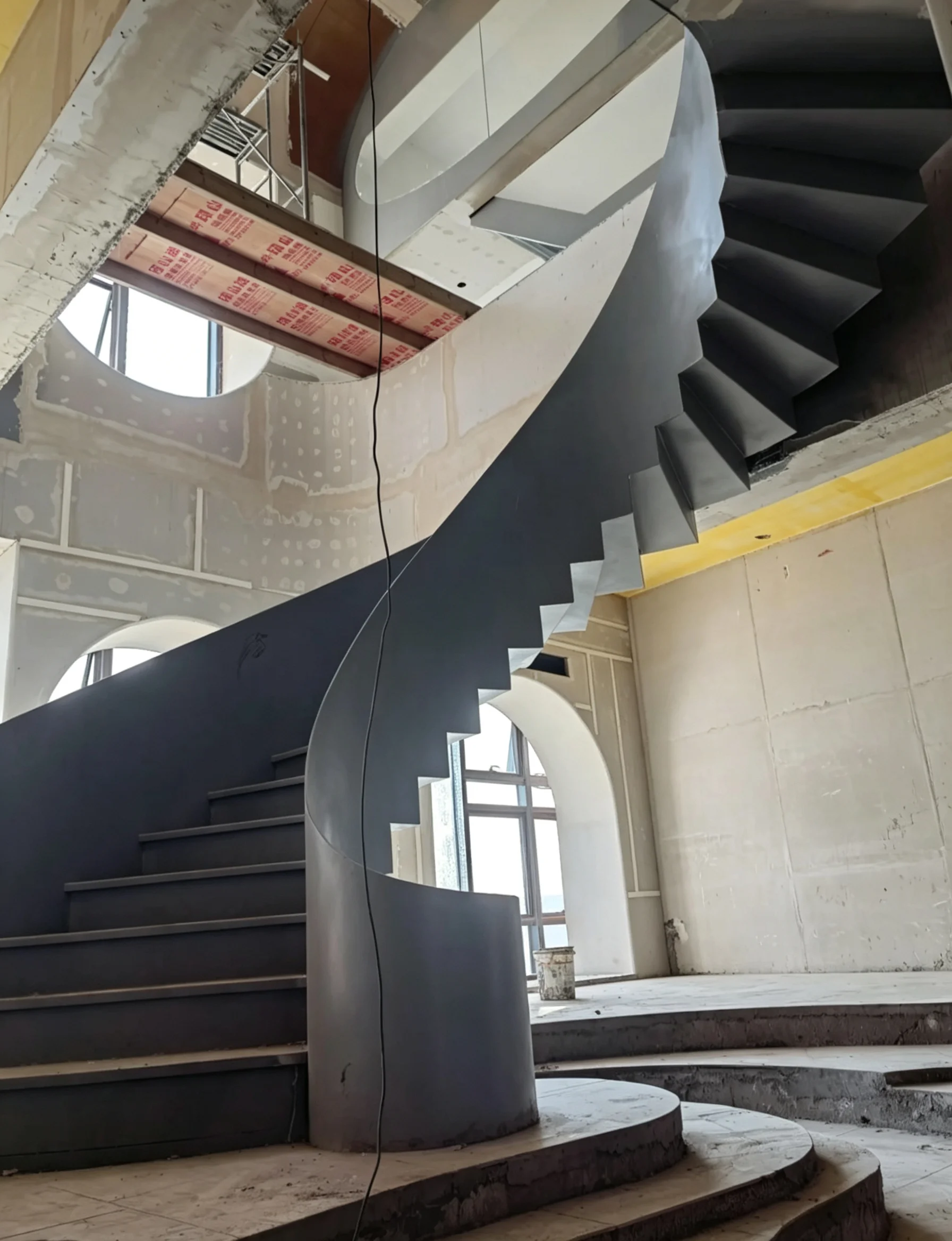Custom curved steel staircase geometry coordinated with floor opening and structural conditions
