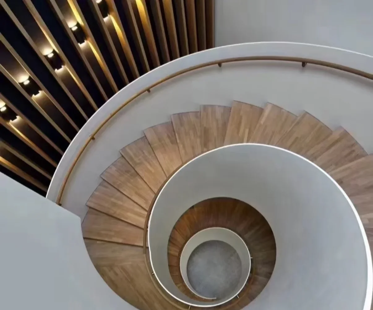 Top view of a helical staircase with timber treads and curved railing